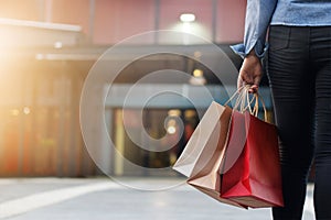 Woman walking with shopping bags on shopping mall background
