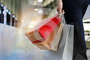 Woman walking with shopping bags on shopping mall background