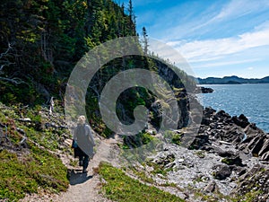 A woman is walking on the shores of Saint Lawrence river, Bic National park, Quebec, Canada photo