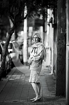Woman walking on the sidewalk in the street. Black and white photo.