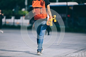 Woman walking with skateboard on city