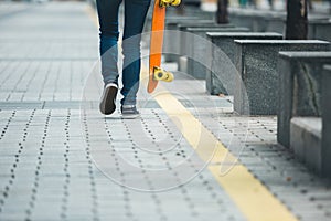 Woman walking with skateboard in hand