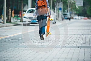 Woman walking with skateboard in hand