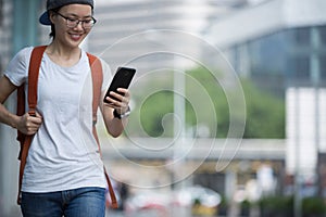 Woman walking with smart phone in modern city