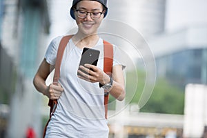 Woman walking with smart phone in modern city