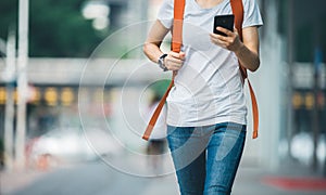 woman walking with smart phone in modern city