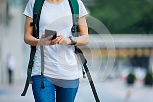 woman walking with smart phone in modern city