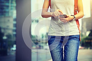 Woman walking with smart phone in modern city