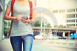 woman walking with smart phone in modern city