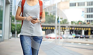 woman walking with smart phone in modern city