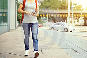 Woman walking with smart phone in modern city