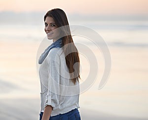 Woman, walking and smile in portrait at beach, sunset and vacation with nature to relax by ocean. Girl, person and