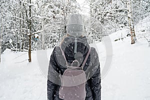 Woman walking in snowy winter forest