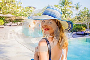 Woman walking by swimming pools on vacation in luxury resort