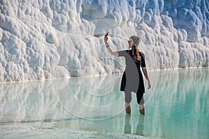 Woman walking on the terraces at Pamukkale. It cotton castle in Turkish and is natural site photo