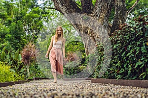 Woman Walking On A Textured Cobble Pavement, Reflexology. Pebble stones on the pavement for foot reflexology