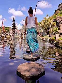 Woman walking in Tirta Ganga Water Palace in Bali, Indonesia