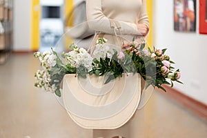 Woman walking to work with a bag with fresh flowers