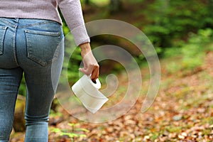 Woman walking with toilet paper in a forest