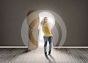 Woman walking towards keyhole shaped doorway with light