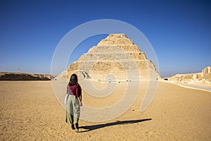 Woman walking towards Pyramid Djoser, Saqqara near Cairo in Egypt