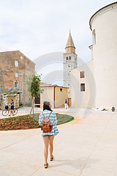 woman walking by umag city looking at showplaces