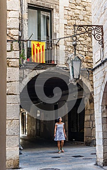 Woman walking under a Estelada flag in Girona. Spain.