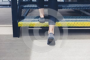 Woman walking up metal stairs