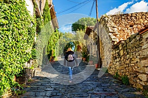 Woman walking up a sloping street in the old stone village, Patones de Arriba. photo