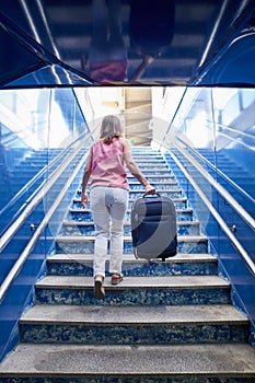 Woman walking up the stairs of a train station