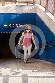 Woman walking up the stairs of a train station