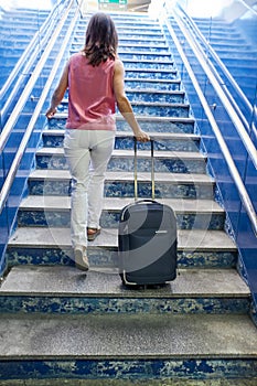 Woman walking up the stairs of a train station