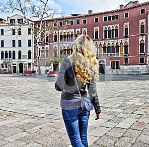 Woman walking in Venice Italy. Traveler or tourist girl exploring the city