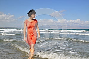 Woman walking in water looking aside