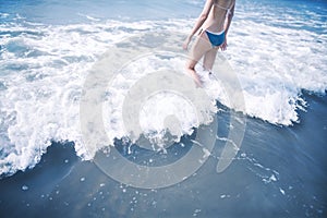 Woman walking into waves at the beach