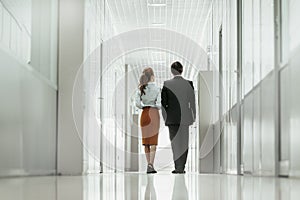 Woman walking with worker indoor during job