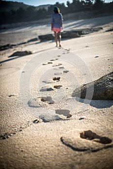 Woman Walks Alone on a Deserted Beach