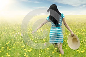 Woman walks on blossom meadow