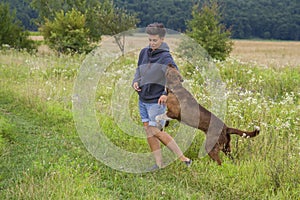 Woman walks with dog of hunting breed