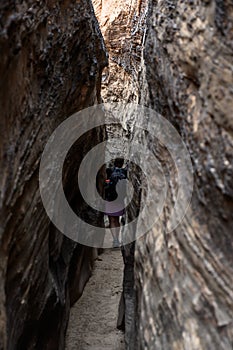 Woman Walks Down Narrow Slot Canyon