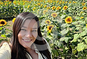 Woman walks through a field of sunflowers full of happiness in fullness, with tranquility, relaxation, calm, peace and splendor