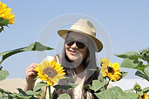Woman walks through a field of sunflowers full of happiness in fullness, with tranquility, relaxation, calm, peace and splendor