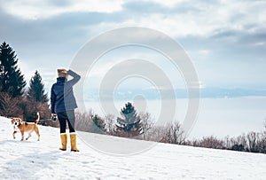 Woman walks with her dog on mountain hill