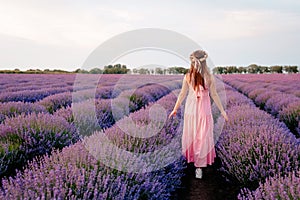 A woman walks in a lavender field enjoying the sight and smell