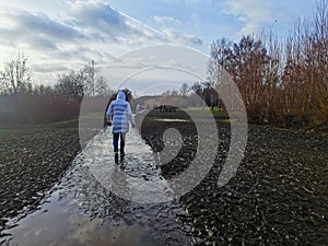 Woman walks on muddy path of a park