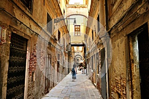 Woman walks through the narrow street of venice