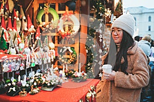A woman walks in the new year city. Purchaser chooses gifts. Girl looks Christmas fair