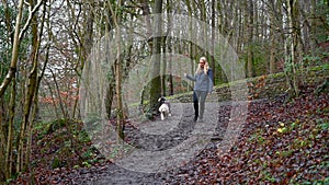 Woman walks Old English Sheepdog puppy down slope