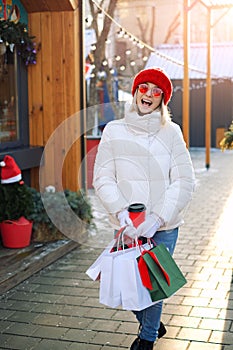 Woman walks among the shops on city streets with bags with gifts