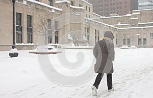 Woman walks to work in winter snowstorm downtown Chicago